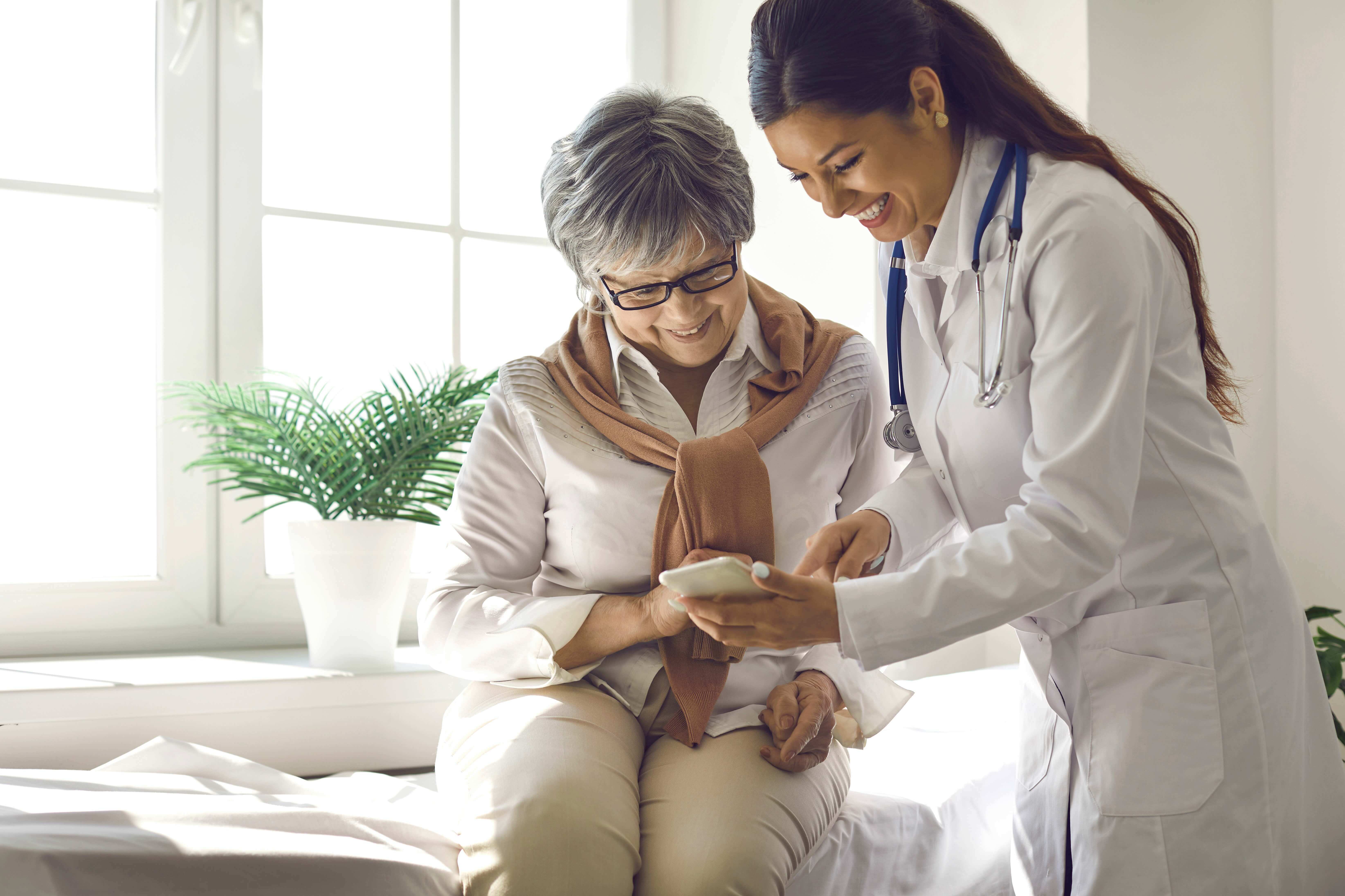 Woman with her doctor looking at a cell phone